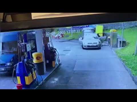 Shocking moment thief sneaks up and steals woman's car as she cleans it at petrol station