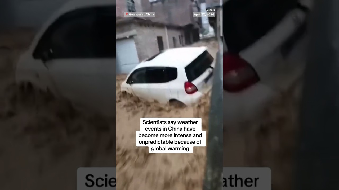 A man watches a car getting swept away by rushing floodwaters in China’s Guangdong province.