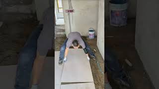 the process of installing large ceramic tiles on the floor in a large room in a building #popular