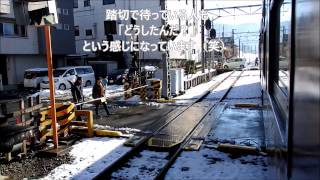 ホームをはみ出して踏切をまたいで停車する列車