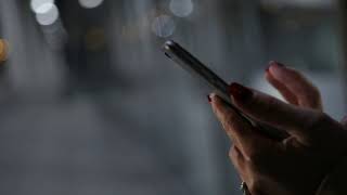 closeup of young woman hands typing sms and scrolling pictures on phone