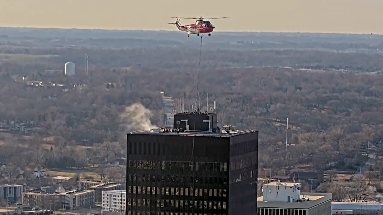 Watch: Helicopter helps crews lift equipment to top of Ruan Center in ...