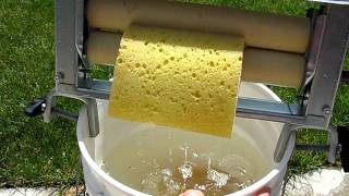 Best hand clothes wringer demonstrating wringing out sponges while attached to 5 gal bucket