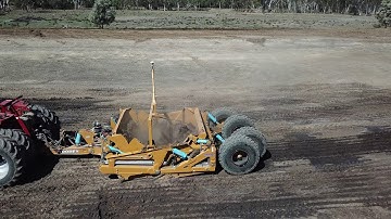 TOOMEY 4000B Scraper behind an STX450 digging in damp black soil using the teeth cutting edges.