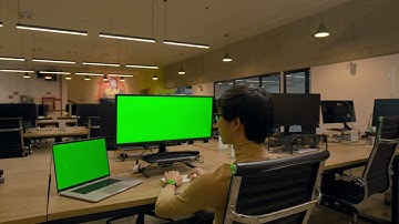 man working on computer with chroma green background