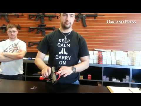 Kevin Bedker ofTargetSports demonstrates how to put cable lock on handgun.