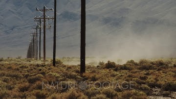Dust Devil, Whirlwind, Desert Tornado Roars a Row of Power Poles in the Mojave Desert