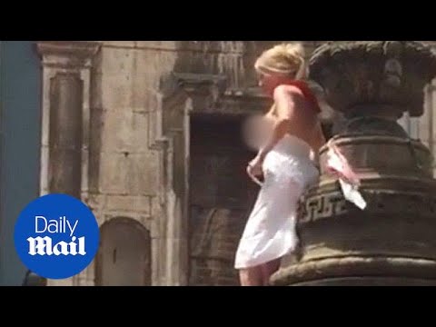 Woman climbs Pamplona landmark to flash her breasts at the crowd - Daily Mail