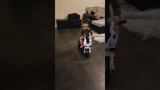 2 years old toddler drives a mini motorcycle.