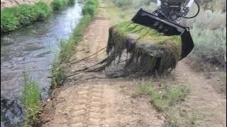 Moss removal with a CMP attachments tilt rotator and skeleton rock bucket