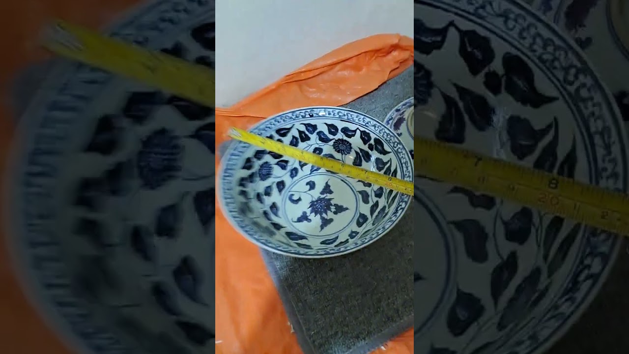 A large blue-and-white porcelain bowl with a floral scroll design