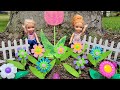 Spring flowers ! Elsa &amp; Anna toddlers are having fun outdoors - Barbie dolls - sand pit