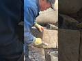 arranging several large stone blocks precisely using a heavy hammer and mortar