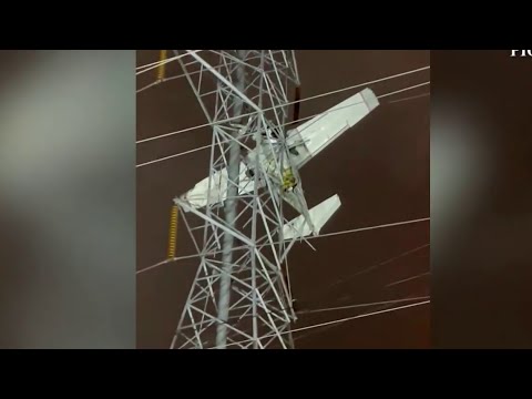 Crews work to rescue 2 in plane caught high in power lines