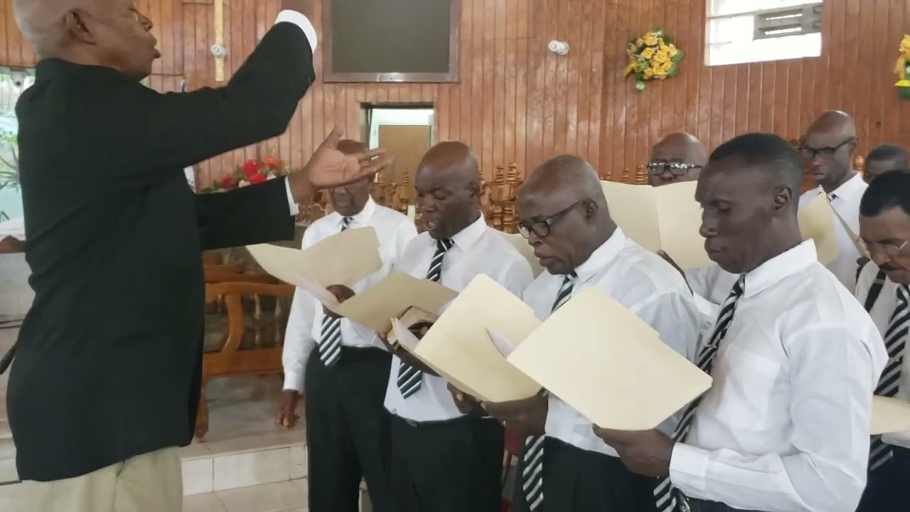 Le chœur d'hommes de la Première Église Baptiste de Port-au-Prince dans :Levons- nous .