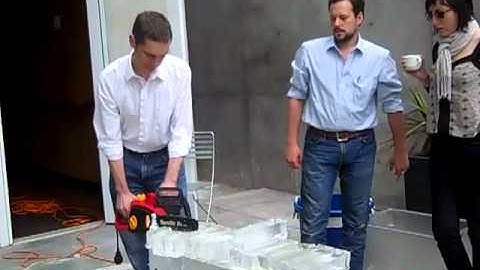 cutting rectangles of ice into cubes with a chainsaw