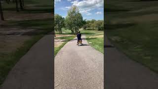 Two boys ride toy rolling horse down hill then falls forward onto grass