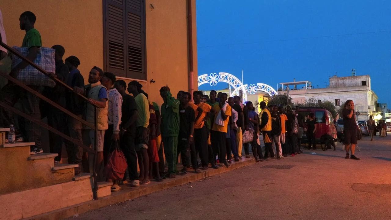 Distribuzione pasti ai migranti: la fila alla chiesa di Lampedusa