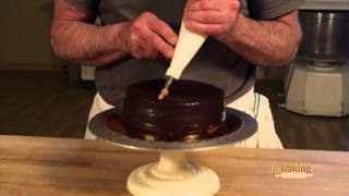 Jeffrey hamelman demonstrates how to decorate a chocolate ganache
cake.