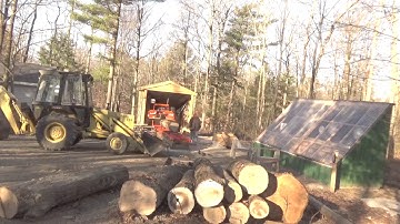 One man loading a log onto the Woodmizer LT15 and making a cant.