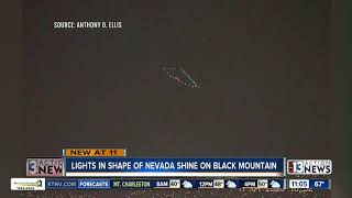 Nevada state outline lit up on mountains near Las Vegas valley