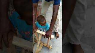 Baby learning walk on wooden 3-wheels vehicle