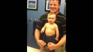 Cute baby flexes muscles with dad