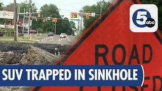 Akron sinkhole swallows SUV, driver rescued by police