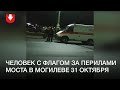 Человек с флагом вылез за перила моста в Могилеве