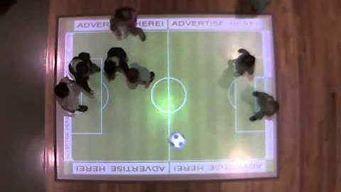 Children playing virtual soccer on an AdVis interactive projection floor system.