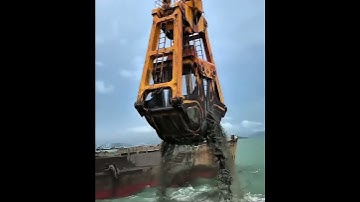 The grab bucket of a grab dredger is grabbing mud