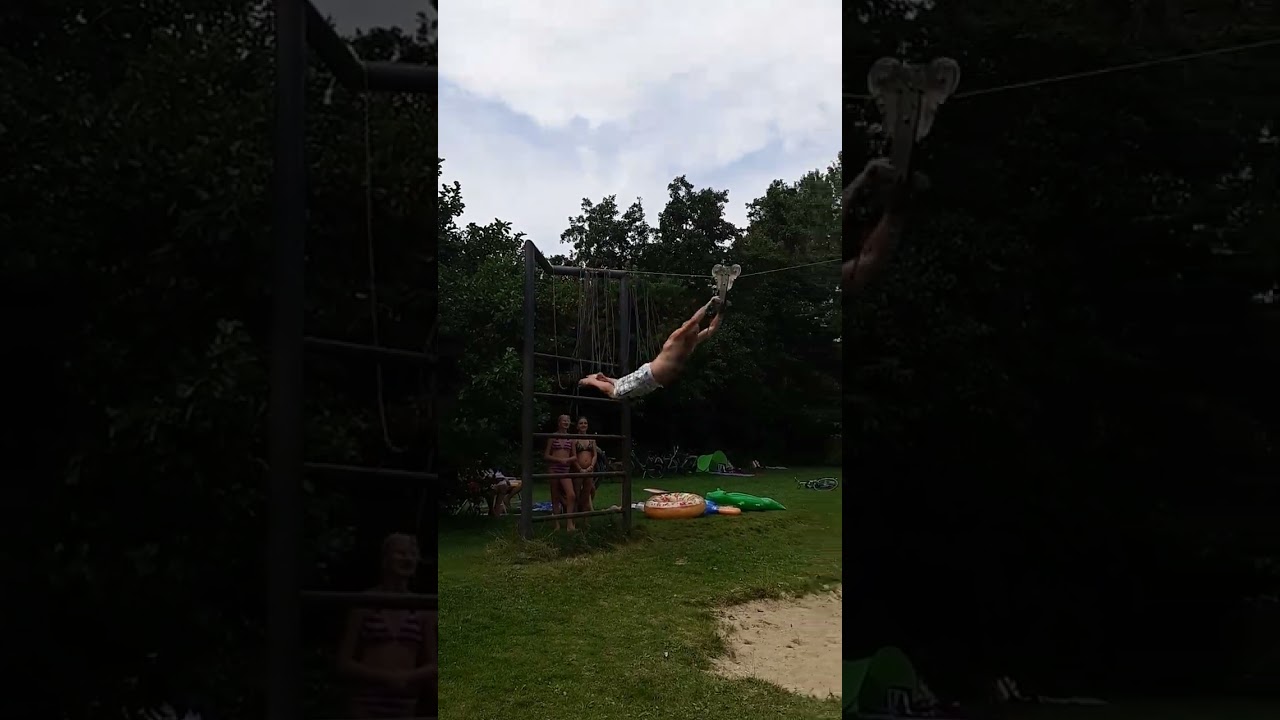 Man rides zipline over lake but falls on his rear by the sand
