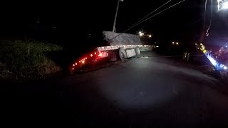 LOADED FLATBED IN A DITCH AGAINST A UTILITY POLE