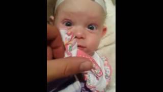 Adorable sleeping baby wakes up surprised to see a camera