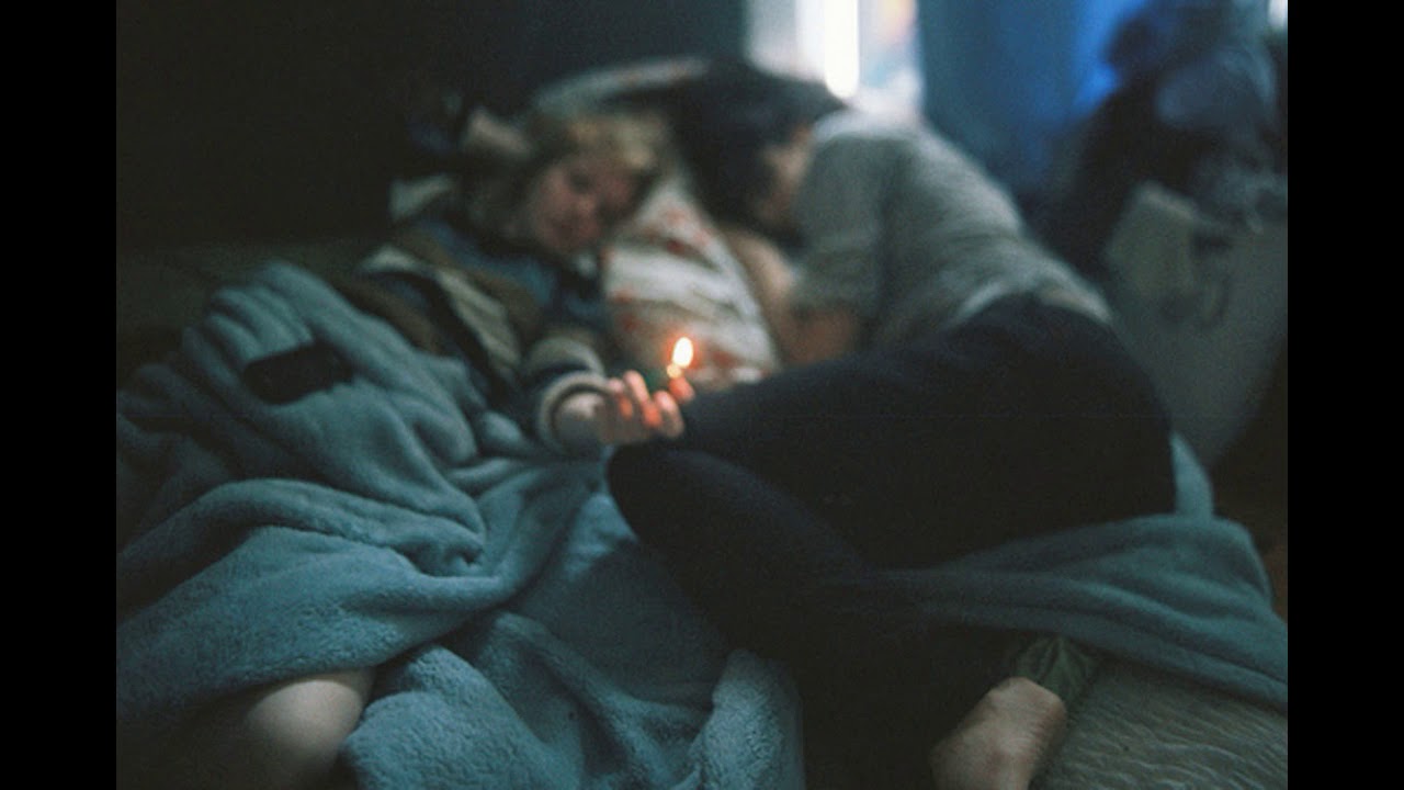 Ночь невыносимо. Под одеялом ночью. Парень и девушка курят в постели. Двое под одеялом. Парень под одеялом в темноте.