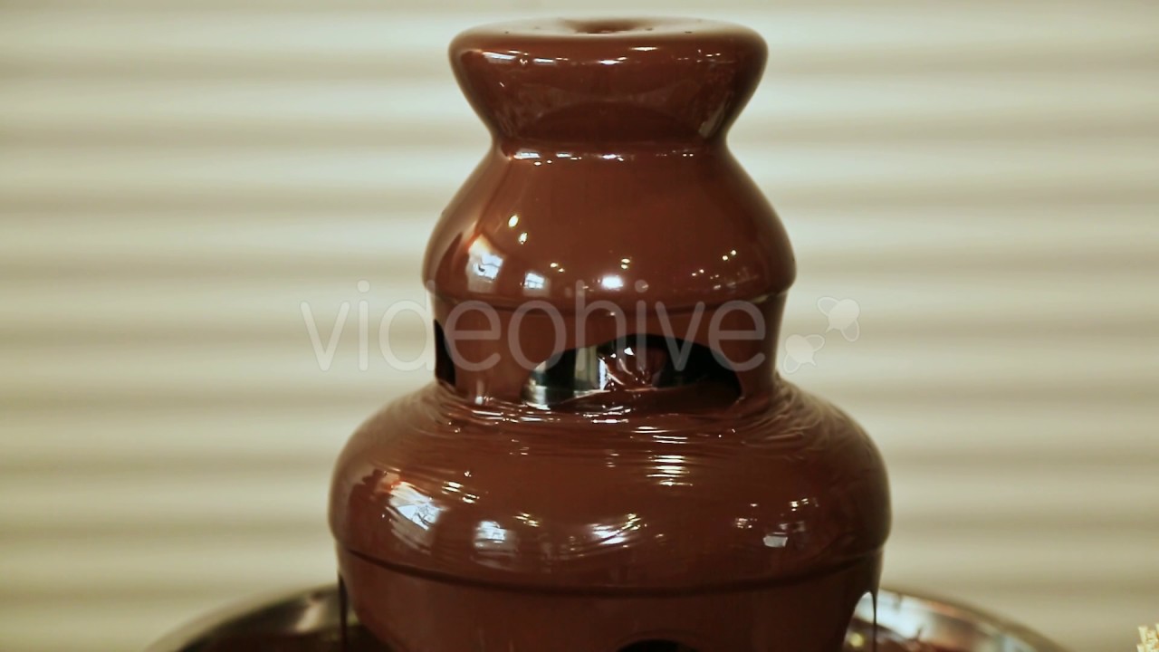 Chocolate fountain hot liquid flowing down tower pyramid YouTube