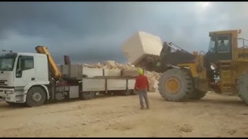 new heavy loader loading granite blocks onto a truck