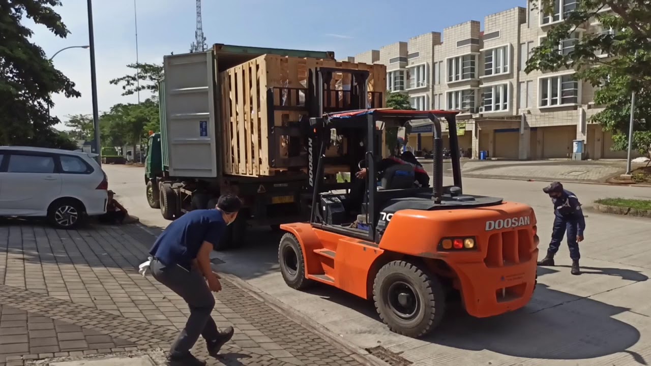 Unloading machine from shipping container with forklift