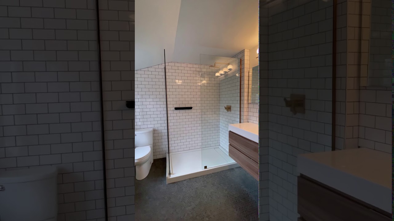 Custom glass shower panels with Antique Brass hardware.