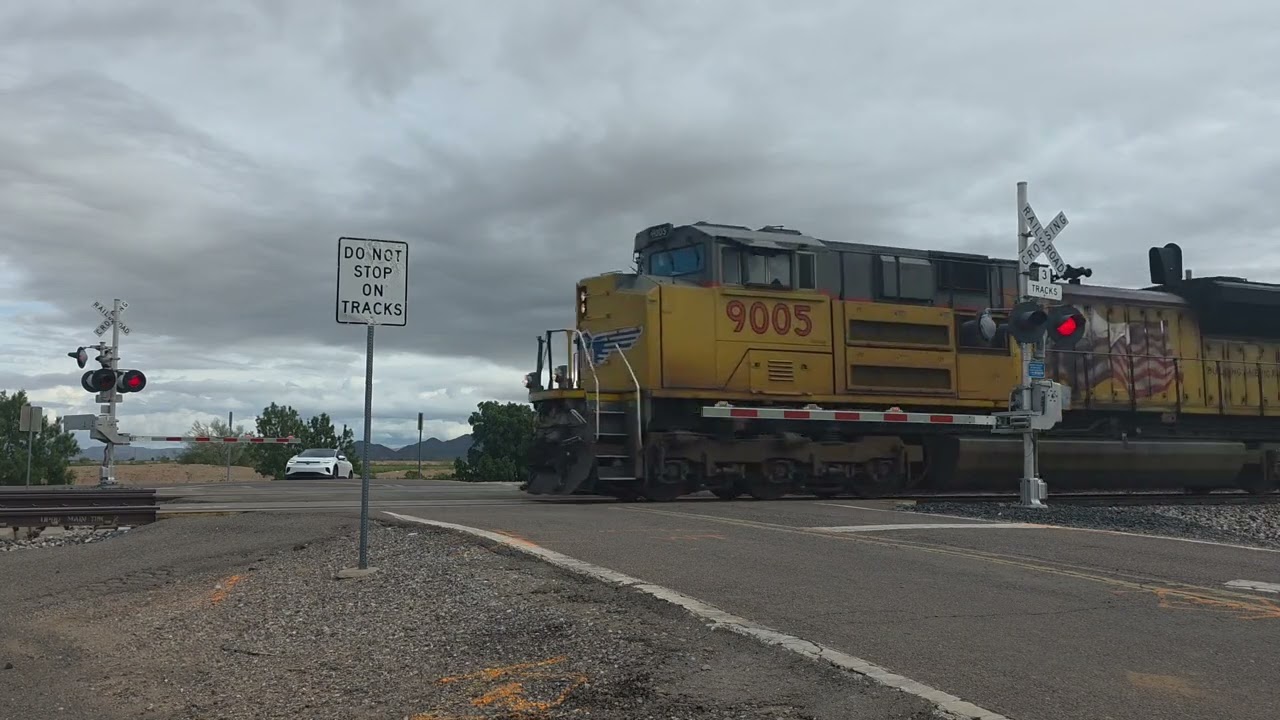 Поезд UP 9005 Autorack с промежуточным локомотивом и новой покраской, железнодорожный переезд на ...
