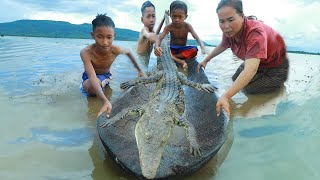 Mountain women cook crocodile near the river