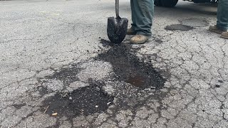 Public Works staff members demonstrate how to fill potholes in Carlisle