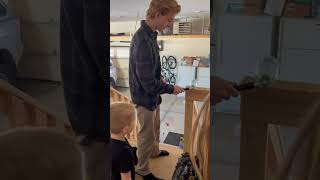 Boy lights bottle rocket inside soda bottle in garage