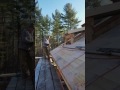 Christopher LaMontagne  puts ice melt on a barn roof he is sheathing