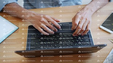 Close-up high angle view of hands typing on laptop keyboard at table indoors