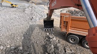 Hıtachı Excavator She loads stony materials onto trucks.