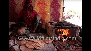 Rajasthani women cook chapatis on a mud stove at Pushkar mela screenshot 4