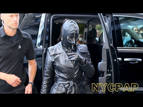 Kim Kardashian checks into her hotel wearing a leather face mask