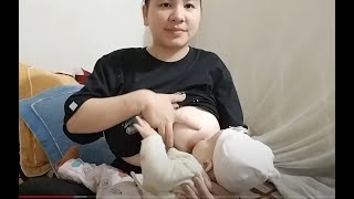 Mother breastfeeds and plays with baby before going to bed
