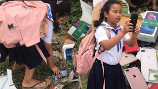 Restore old Phones, schoolgirls pick up on the street near the trash can to repair